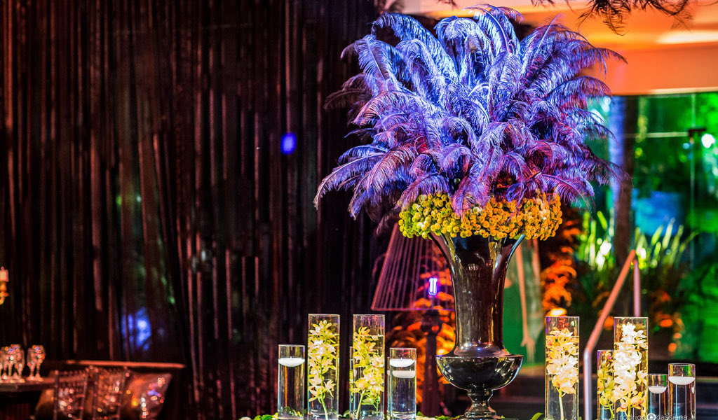 Arranjo de plumas e flores sobre a mesa dos convidados